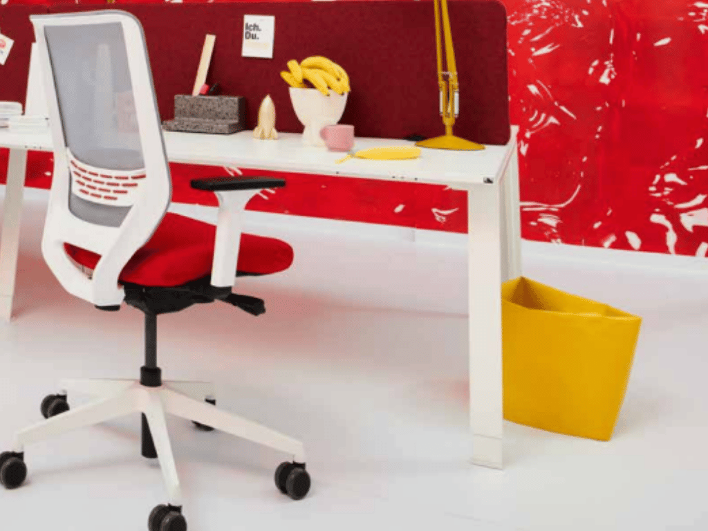 Siège de bureau Sync à roulettes. Assise rouge , dossier blanc. Piétement en étoile.